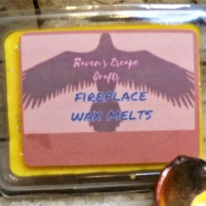 May include: A yellow and pink wax melt label with a silhouette of a raven with the text "Raven's Escape Crafty Fireplace Wax Melts".