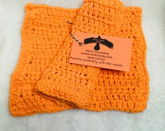 May include: Two orange crocheted dishcloths made of 100% cotton. The dishcloths are hand crocheted and machine washable and dryable with like colors. The tag reads "Hand Crocheted Washcloth/Dishcloth 100% Cotton Machine Wash/Dry with like colors".