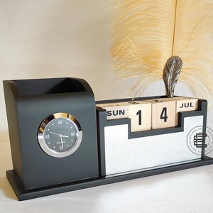 May include: Black desk organizer with a clock, pen holder, and a wooden calendar that says "JUL 14 SUN".