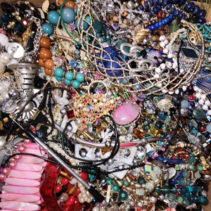 May include: A large assortment of jewelry, including necklaces, bracelets, and earrings, in various colors and styles. The collection features pearls, beads, and metal accents. A variety of textures and shapes are visible, creating a diverse and eye-catching display.