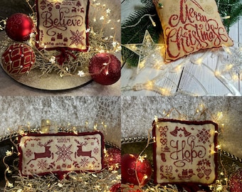 Może przedstawiać: Cztery świąteczne, haftowane ozdoby w kolorach czerwonym i kremowym. Jedna mówi "Believe 2024", druga "Merry Christmas", trzecia ma renifery i płatki śniegu, a ostatnia "Hope 2025". Czerwone bombki i lampki otaczają je.