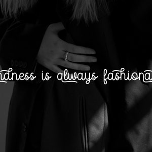 May include: Black and white photo of a person wearing a black jacket with the text "Kindness is always fashionable" in white.