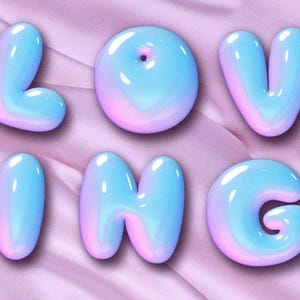 Puede incluir: Seis letras de burbujas 3D que deletrean la palabra "LOVING" en un degradado de tonos azules y rosas. Las letras son brillantes y parecen flotar sobre un fondo de tela rosa suave.