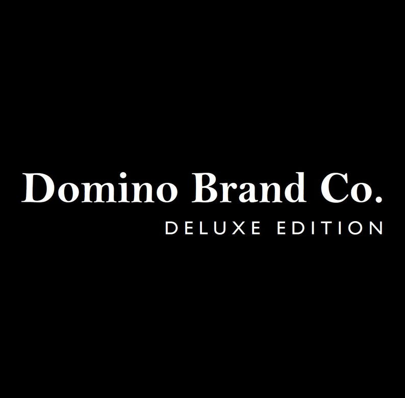 May include: White text on a black background reads "Domino Brand Co." in a serif font, with "DELUXE EDITION" below in a smaller font. The text is centrally aligned.