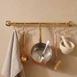 Keukenrek van ongelakte messing met haken.