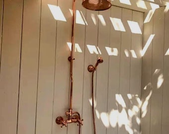 Ducha exterior de cobre macizo sin lacar con cabezal de ducha de cobre.