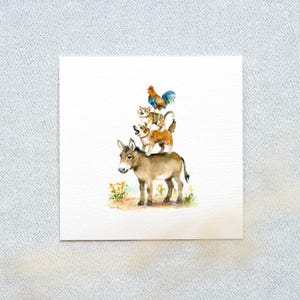 Può includere: Illustrazione ad acquerello di un asino, due cani, un gatto e un gallo impilati l'uno sull'altro. Gli animali sono dipinti con colori tenui e naturali, su sfondo bianco. Fiori gialli alla base dell'asino.