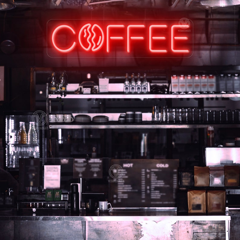 May include: A red neon sign with the word "COFFEE" and a stylised coffee bean graphic. The sign is mounted on a wall above a counter in a coffee shop.