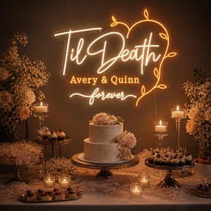 May include: A warm-toned neon sign displaying the text Til Death, Avery & Quinn, and forever in a cursive script, framed by a glowing heart outline. The sign is mounted above a two-tiered white cake and several small dessert stands with candles.
