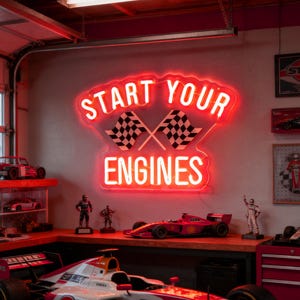 Może przedstawiać: Czerwony neon z napisem "START YOUR ENGINES" i dwiema szachownicami. Nad półką z modelami samochodów wyścigowych i figurkami. Ogólny motyw to sporty motorowe.