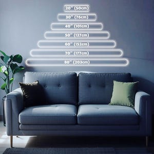 May include: A gray two-cushion sofa with a green and a brown pillow. Above the sofa, a series of illuminated white lines indicate lengths from 20 inches (50cm) to 80 inches (203cm), with corresponding centimeter measurements.