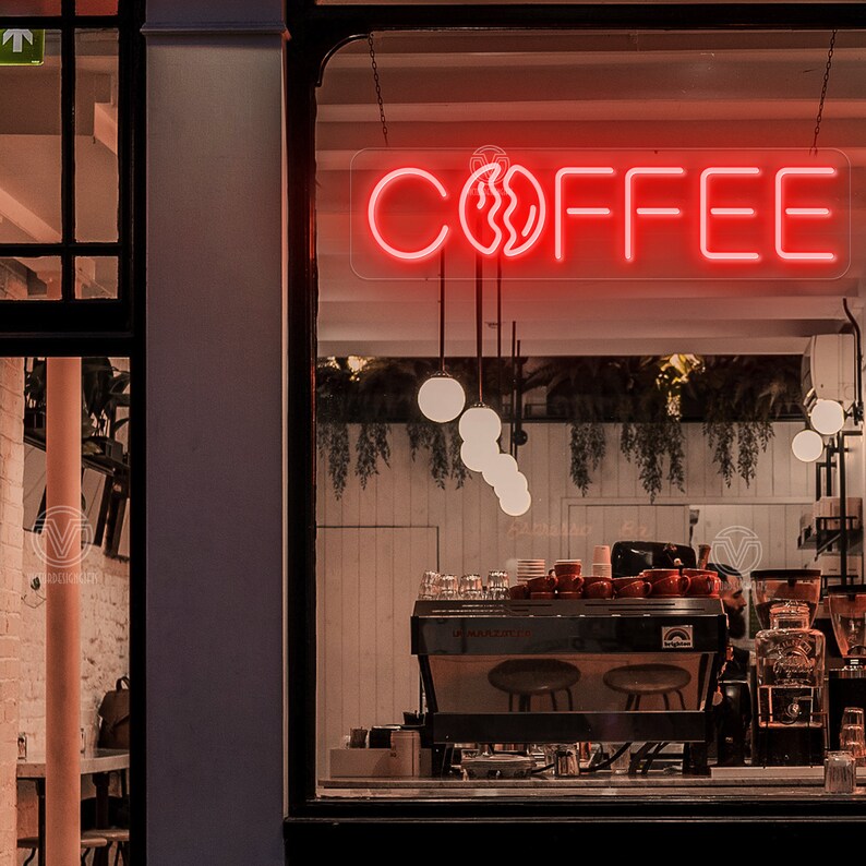 May include: A red neon sign with the word "COFFEE" and a stylised coffee bean graphic hanging in a window of a coffee shop.