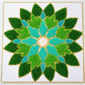 Puede incluir: Un diseño en forma de flor verde y azul hecho con granos de arroz sobre un fondo blanco.