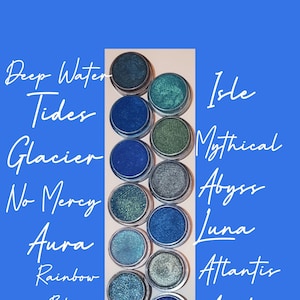 Può includere: Una collezione di 10 ombretti blu piccoli e rotondi in contenitori metallici. Gli ombretti sono etichettati con nomi come "Deep Water Tides", "Glacier", "No Mercy", "Aura", "Rainbow Blue", "Bermuda", "Nova", "Isle", "Mythical Abyss", "Luna", "Atlantis", "Arctic", "Navy" e "Nebula".