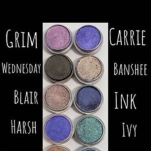 May include: Ten small round eyeshadow palettes in silver containers with various shades of blue, purple, green, and brown. The palettes are labeled with names like "Grim", "Carrie", "Wednesday", "Banshee", "Blair", "Ink", "Harsh", "Ivy", "Sombre", and "Resonate".