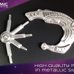 May include: Two metallic silver 3D-printed objects. One is a curved, ornate shape with a star design, and the other is a circular piece with radiating arms. The text "HIGH QUALITY PRINT in METALLIC SILVER" is visible.
