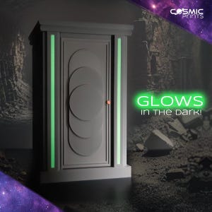 Könnte beinhalten: Ein grauer Schrank mit einer Tür mit einem kreisförmigen Design und einem kleinen, runden, orangefarbenen Griff. Der Schrank hat vertikale, grün leuchtende Streifen an den Seiten und den Text "GLOWS in the DARK!" in Grün.