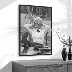 a black and white photo of a woman sitting in a chair