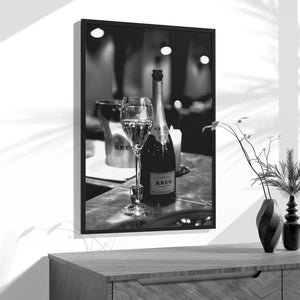 a black and white photo of a bottle of wine and two glasses