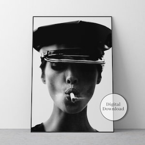 Può includere: Stampa di un ritratto in bianco e nero di una persona con un berretto di pelle che fuma una sigaretta. L'immagine è incorniciata in nero e include un cerchio bianco con la scritta "Digital Download".