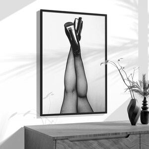 a black and white photo of a woman's legs in stockings