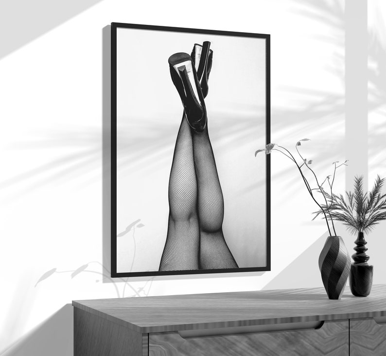 a black and white photo of a woman's legs in stockings