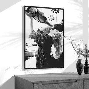 a black and white photo of a woman drinking from a bottle