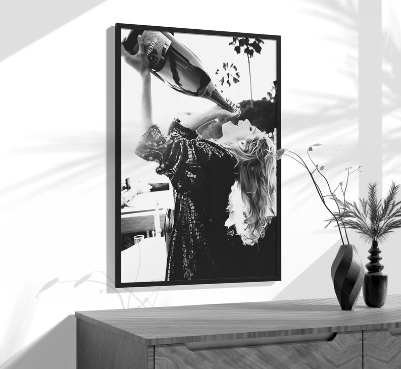 a black and white photo of a woman drinking from a bottle