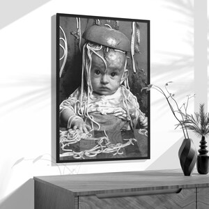a black and white photo of a baby wearing a hat