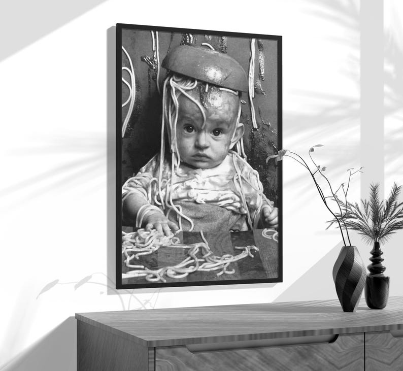 a black and white photo of a baby wearing a hat