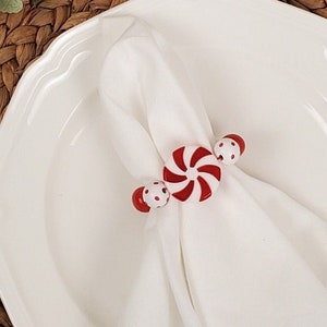 May include: White napkin ring with a red and white candy cane design and red and white polka dot accents.