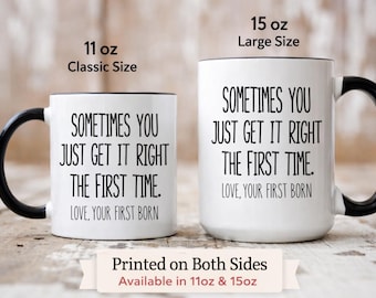May include: Two white ceramic mugs with black handles and rims. The mugs have the text "SOMETIMES YOU JUST GET IT RIGHT THE FIRST TIME. LOVE, YOUR FIRST BORN" printed on them. One mug is 312 ml, the other is 425 ml.