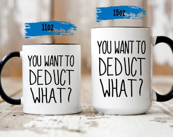 Puede incluir: Dos tazas de café blancas con asas y bordes negros. Las tazas tienen el texto "You want to deduct what?" impreso en ellas. La taza más pequeña es de 11 oz y la taza más grande es de 15 oz.