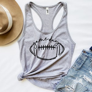 May include: Gray tank top with a black graphic of a football and the text "game day".