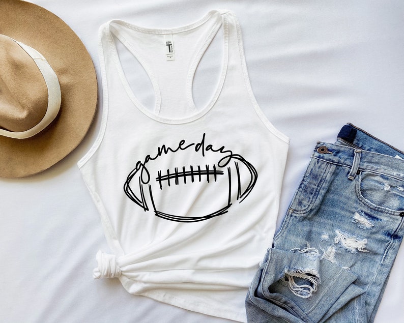 May include: White tank top with a black graphic of a football and the text "game day".