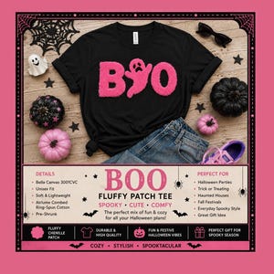 May include: A black t-shirt featuring the word BOO in pink fuzzy chenille letters, with the letter O replaced by a ghost shape. The shirt is displayed with black and pink pumpkins, a ghost figurine, sunglasses, and a pair of purple sneakers.