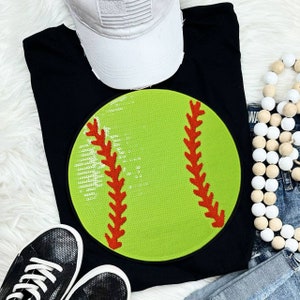 May include: Black t-shirt with a green and red sequin softball design.
