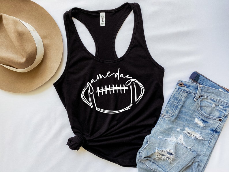 May include: Black tank top with a white graphic of a football and the text "game day".
