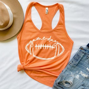 May include: Orange tank top with a white graphic of a football and the text "game day".