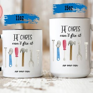 May include: Two white ceramic mugs with black handles. The mugs have a black rim and a design of tools with the text "If Chris can't fix it, no one can". The smaller mug is 11 oz and the larger mug is 15 oz.