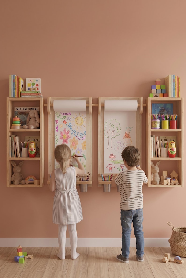May include: A wall-mounted wooden art station featuring two vertical paper roll dispensers, two integrated shelves for supplies, and two flanking bookcases filled with children's books, toys, and colorful art materials.