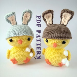 May include: Two crocheted yellow chick toys with bunny ears. One chick is wearing a light blue hat and the other is wearing a brown hat.  The text "PDF PATTERN" is visible in the image.