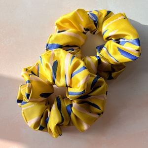 May include: Two yellow scrunchies with blue and pink abstract patterns.