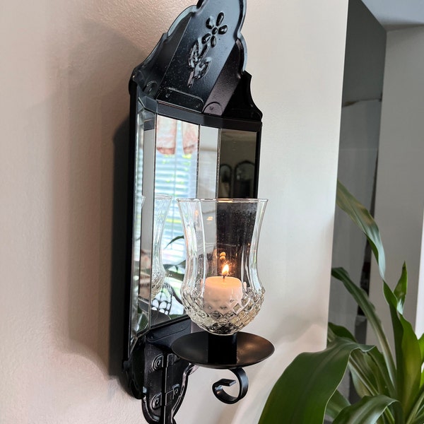 Vintage mirrored metal wall sconce with embossed flower, painted black, includes multi-faceted glass globe.