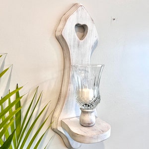Wood wall sconce with heart cutout and glass globe, painted white and distressed