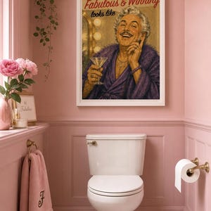 Pode incluir: Uma impressão artística emoldurada com uma ilustração de estilo vintage de uma pessoa sorridente com um roupão roxo segurando uma taça de martini, com o texto Darling, this is what Fabulous & Winning looks like em letras pretas e vermelhas.