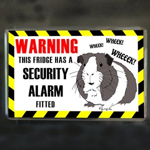 May include: A yellow and black warning sign with the text "WARNING THIS FRIDGE HAS A SECURITY ALARM FITTED". A cartoon guinea pig with the text "WHEEK!" is in the upper right corner of the sign.