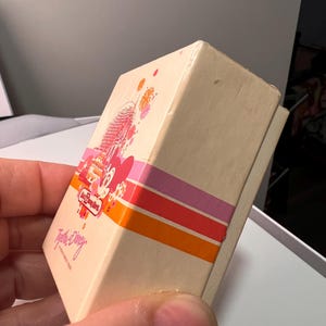 May include: A rectangular cream-colored box featuring a Walt Disney World logo, a graphic of Spaceship Earth, and a pink Minnie Mouse character. The box includes horizontal orange, red, and pink stripes and the text Together at Disney.