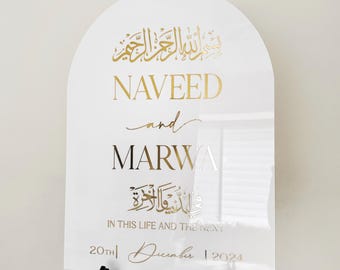 May include: White arch-shaped sign with gold lettering announcing the wedding of Naveed and Marwa. The sign includes Arabic calligraphy and the date "20th December 2024".