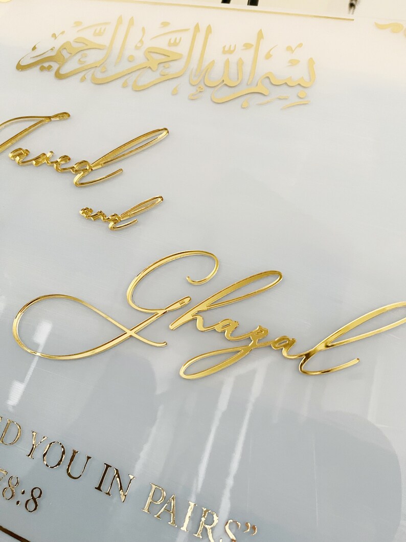 May include: A white background with gold lettering. The text reads "And you in pairs" and "7:8" in a smaller font. The names "Taimur" and "Shayal" are written in cursive.